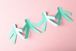 Paper cutout figures holding hands symbolizing long-term stability for children in organizational care.