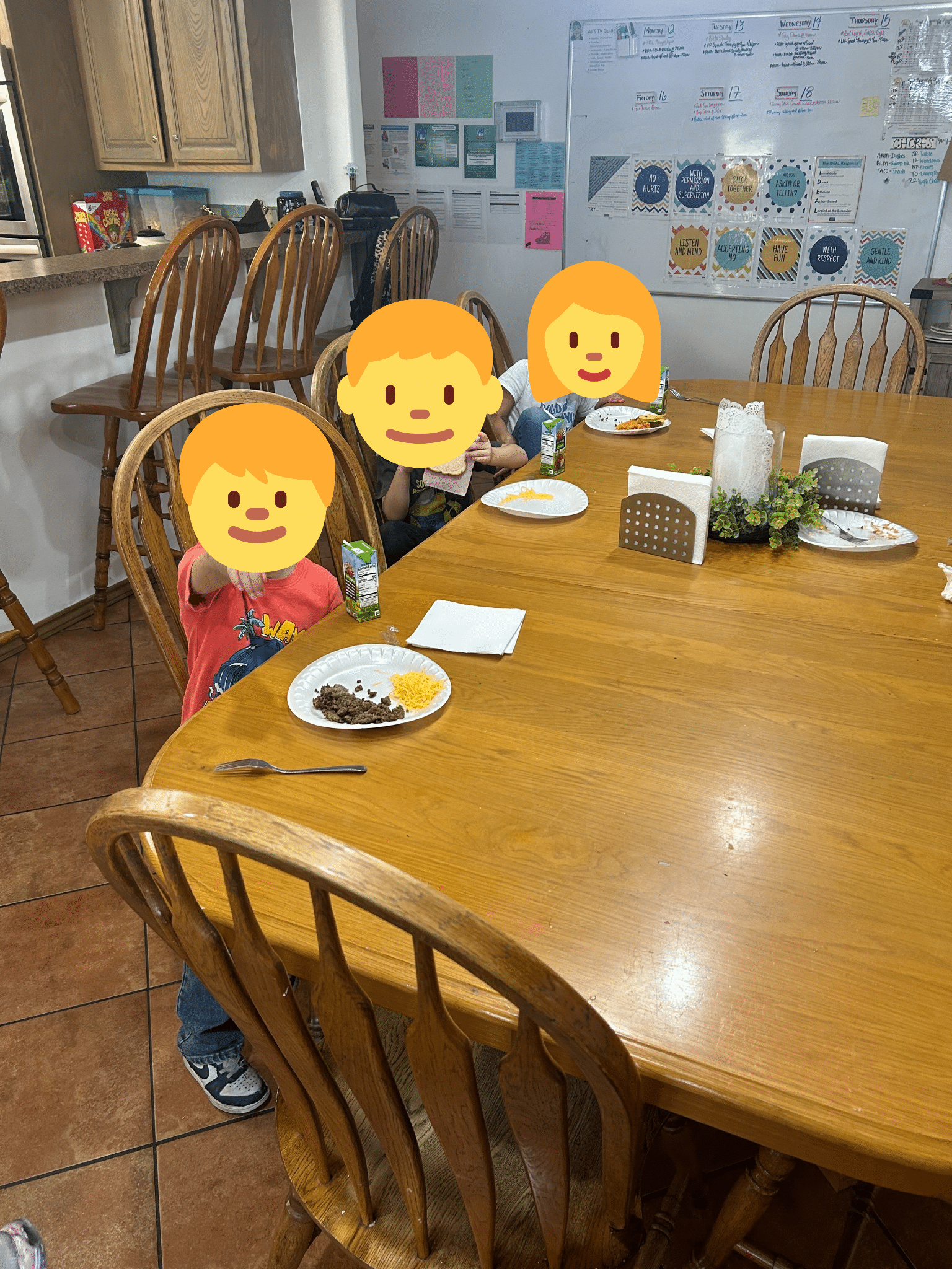 Children gather around a dining table for a shared meal, reflecting family style routines, daily care, and the sense of connection that helps children feel safe and supported. 