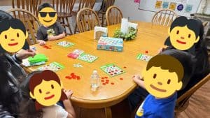 A group of children play a tabletop game, with Sunny Glen Children’s Home impact numbers reflected in daily routines of care, structure, and belonging.