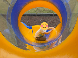 Child at Sunny Glen Children’s Home playing joyfully on the playground, with everyday needs supported through the Foster Care Needs List.