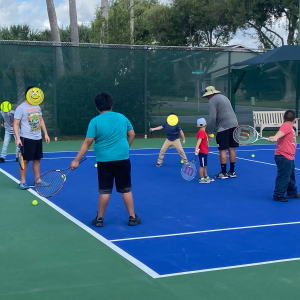 Children from Sunny Glen Children's Home enjoy a tennis lesson during a group outing, showing the joy that comes from sharing the mission of Sunny Glen through community activities and enrichment