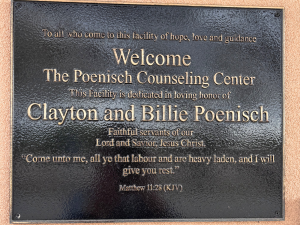 Dedication plaque at the Poenisch Counseling Center honoring Clayton and Billie Poenisch, featuring a Scripture verse from Matthew 11:28
