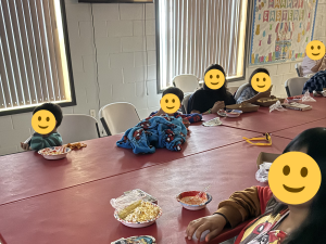 Children gathered around a table enjoying popcorn and snacks during a Sunny Glen movie night, proving foster care myths wrong — kids here just get to be kids.